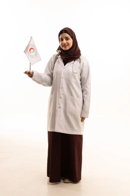 Looking at the camera with expressions of happiness, contributing to humanitarian and social services, providing emergency medical first aid, the flag of the Saudi Red Crescent Authority, working in the medical field, a portrait of a Saudi Arabian Gulf female doctor wearing a white coat and hijab holding the Red Crescent flag in her hands, full-body, white background.