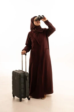 Seeing distant things through binoculars, a love for exploration and adventure, a portrait of a veiled Saudi Gulf Arab woman wearing an abaya, holding binoculars in one hand and a travel bag in the other, enjoying pleasant times during vacation, preparing for a tourist trip, full-body image, white background.