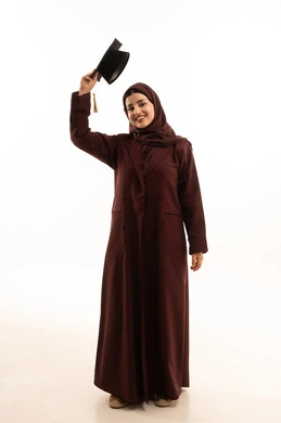 تعابير البهجة والسعادة بالوصول لحلم النجاح، مفهوم الاجتهاد والتفوق، الاحتفال بإنهاء الدراسة الجامعية, بورتريه لخريجة عربية سعودية خليجية محجبة ترتدي العباءة تمسك بيدها قبعة التخرج و ترفعها للاعلى، النظر إلى الكاميرا بإيماءات السرور والفخر، الجسم بالطول الكامل، خلفية بيضاء