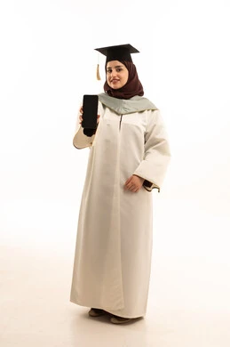 عرض شاشة سوداء فارغة على الهاتف المحمول، بورتريه لخريجة عربية خليجية سعودية ترتدي القبعة وزي التخرج تنظر الى الكامير بتعابير السرور والسعادة، تطبيقات الدراسة اونلاين، الاحتفال بانتهاء المرحلة الجامعية، الجسم بالطول الكامل، خلفية بيضاء