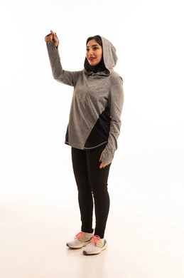 Setting a specific goal, gestures of joy and happiness, a healthy and beneficial lifestyle, the concept of agility and fitness, women's physical activities, strengthening muscles and body sculpting, a portrait of a young Arab Gulf Saudi woman wearing sportswear pointing to something, white background.