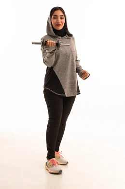 Healthy lifestyle, portrait of a Saudi Gulf Arab girl wearing sportswear, exercising with dumbbells, physical activity to maintain health and physical fitness, weightlifting exercises (dumbbells), lifting heavy weights, full-length image, white background.