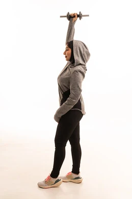Lifting heavy weights, a portrait of a Saudi Gulf Arab girl wearing sportswear, exercising with dumbbells, physical activity to maintain health and physical fitness, a healthy lifestyle, weightlifting exercises (dumbbells), full-length image, white background.