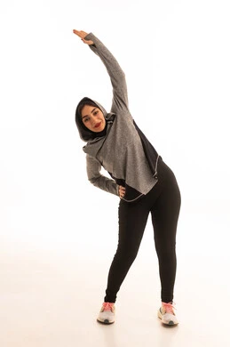 The concept of agility and fitness, a healthy and beneficial lifestyle, women's physical activities, muscle strengthening and body sculpting, a portrait of a young Arab Gulf Saudi woman wearing sportswear exercising, white background.