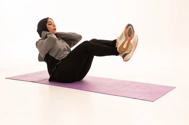 المحافظة على التوازن الجسدي، نمط حياة صحي ومفيد، ممارسة التمرينات الأرضية لشد الجسد، مفهوم الرشاقة واللياقة، انشطة بدنية نسائية، تقوية العضلات ونحت الجسم، بورتريه لشابة عربية خليجية سعودية ترتدي زي رياضي تقوم بممارسة التمرينات الرياضية ،إيماءات الحماس و النشاط، خلفية بيضاء