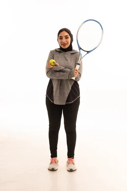 A game characterized by focus and quick thinking, a portrait of a Saudi Arabian Gulf woman wearing a hijab dressed in special attire for the game and playing tennis, a fun and beneficial sport, training to master the game, practicing a favorite hobby, entertainment and recreation, health and fitness. A game characterized by focus and quick thinking, a portrait of a Saudi Arabian Gulf woman wearing a hijab dressed in special attire for the game and playing tennis, a fun and beneficial sport, training to master the game, practicing a favorite hobby, entertainment and recreation, health and fitness.