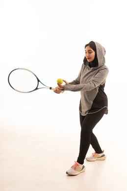 بورتريه لإمراه عربيه سعوديه خليجيه محجبه ترتدي لباس خاص باللعبه و تلعب لعبة التنس, رياضه ممتعه ومفيده, لعبه تتميز بالتركيز وسرعة البديهه, التدريب على اتقان اللعبه, ممارسة الهواية المفضله, تسليه وترفيه, صحه ولياقه