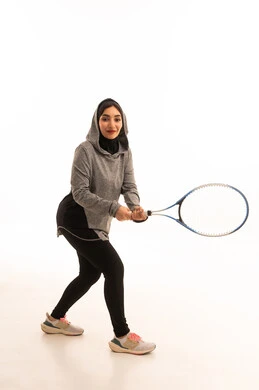 مفهوم الصحه واللياقه، بورتريه لإمراه عربيه سعوديه خليجيه محجبه ترتدي لباس خاص باللعبه و تلعب لعبة التنس, رياضه ممتعه ومفيده, لعبه تتميز بالتركيز وسرعة البديهه, التدريب على اتقان اللعبه, ممارسة الهواية المفضله, تسليه وترفيه