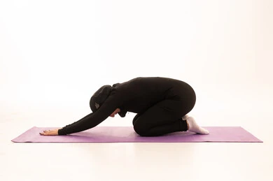 The concept of agility and fitness, maintaining physical balance, a healthy and beneficial lifestyle, practicing floor exercises to tone the body, women's physical activities, strengthening muscles and sculpting the body, a portrait of a young Arab Gulf Saudi woman wearing sportswear practicing sports exercises, gestures of enthusiasm and activity, white background.