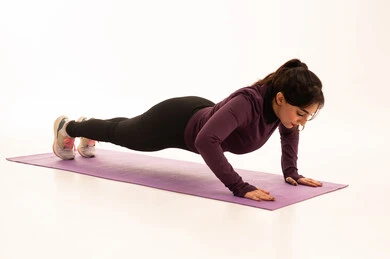 ممارسة تمارين كرة بيلاتيس والتوزان، ممارسة التمارين الرياضية مع كرة اللياقة البدنية،فتاة عربية خليجية سعودية ترتدي الملابس الرياضية،  نشاط بدني للمحافظة على الصحة واللياقة الجسدية، أسلوب حياة صحي،خلفية بيضاء