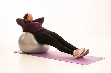 فتاة عربية خليجية سعودية، ترتدي الملابس الرياضية، ممارسة التمارين الرياضية مع كرة اللياقة البدنية، نشاط بدني للمحافظة على الصحة واللياقة الجسدية، أسلوب حياة صحي، ممارسة تمارين كرة بيلاتيس والتوزان، خلفية بيضاء