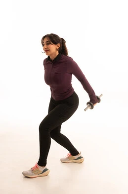 بورتريه لفتاة عربية خليجية سعودية ترتدي الملابس الرياضية، ممارسة التمارين الرياضية مع الدمبل، نشاط بدني للمحافظة على الصحة واللياقة الجسدية،  أسلوب حياة صحي، تمارين رفع الأثقال (دمبلز)، رفع الأوزان الحديدية الثقيلة، صورة بالطول الكامل، خلفية بيضاء