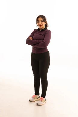 Gestures of joy and happiness, a healthy and beneficial lifestyle, the concept of fitness and agility, women's physical activities, muscle strengthening and body sculpting, a portrait of a young Arab Gulf Saudi woman wearing sportswear looking at the camera, white background.