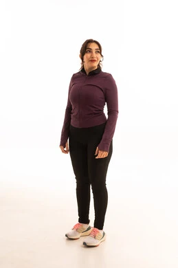 مفهوم الرشاقة واللياقة،ايماءات السرور والسعادة، نمط حياة صحي ومفيد، انشطة بدنية نسائية، تقوية العضلات ونحت الجسم، بورتريه لشابة عربية خليجية سعودية ترتدي زي رياضي تنظر الى شئ ما  ، خلفية بيضاء