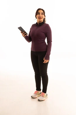 استخدام التقنيات الحديثة ، الدردشة عبر الانترنت، الاطمئنان على الاهل والاصدقاء،مفهوم الرشاقة واللياقة،انشطة بدنية نسائية، تقوية العضلات ونحت الجسم، بورتريه من الجانب لشابة عربية خليجية سعودية ترتدي زي رياضي تستخدم الجوال، خلفية بيضاء