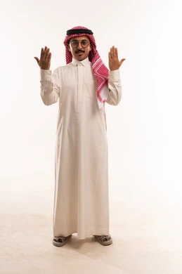Raising the hands up and lifting the palms, the concept of masculinity and toughness, attention to external appearance and elegance, standing upright and looking towards the camera, a portrait of an Arab Gulf Saudi man wearing traditional attire and a shemagh, a young Saudi man wearing glasses, full-body image, white background. Raising the hands up and lifting the palms, the concept of masculinity and toughness, attention to external appearance and elegance, standing upright and looking towards the camera, a portrait of an Arab Gulf Saudi man wearing traditional attire and a shemagh, a young Saudi man wearing glasses, full-body image, white background.