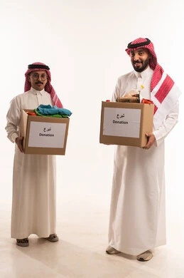 توزيع الحصص المجهزة، التبرع لمشروع السلة الغذائية، جمعيات اسلامية في السعودية،  بورتريه لرجلان خليجيان عربيان سعوديان يقومان بتجهيز صندوق المواد الغذائية وملابس، توفير الطعام للمحتاجين، مبادرات وتبرعات انسانية خيرية،  شهر رمضان، الجسم بالطول الكامل، خلفية بيضاء