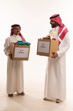 مبادرات وتبرعات انسانية خيرية، التبرع لمشروع السلة الغذائية، جمعيات اسلامية في السعودية،  بورتريه لرجلان خليجيان عربيان سعوديان يقومان بتجهيز صندوق المواد الغذائية وملابس، توفير الطعام للمحتاجين، توزيع الحصص المجهزة، شهر رمضان، الجسم بالطول الكامل، خلفية بيضاء