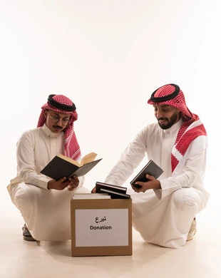 جمعيات اسلامية في السعودية، التبرع لمشروع الكتب والمستلزمات المدرسية،المساعدة على التعلم من خلا مبادرات وتبرعات انسانية خيرية،  بورتريه لرجلان خليجيان عربيان سعوديان يقومان بتجهيز صندوق التبرع، توزيع الحصص المجهزة، خلفية بيضاء