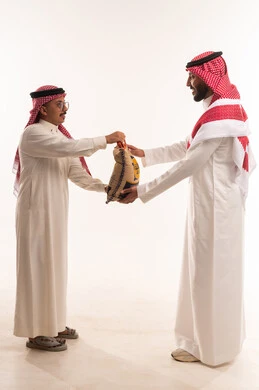 كيس أرز للتبرع في شهر رمضان،جمعيات اسلامية في السعودية، التبرع لمشروع اطعام الجائع، المساعدة على اطعام الصائمين المساكين في أيام فضيلة،  بورتريه لرجلان خليجيان عربيان سعوديان يقومان بتجهيز صندوق التبرع، توزيع الحصص المجهزة، خلفية بيضاء