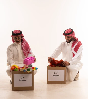 العمل بروح الفريق، توفير وسائل التسلية والترفيه والملابس، ألعاب أطفال للتبرع وادخال البهجة على قلب الصغار،المشاركة في الثواب،  جمعيات اسلامية في السعودية، المساعدة على توفير الاحتياجات، بورتريه لرجلان خليجيان عربيان سعوديان ، خلفية بيضاء