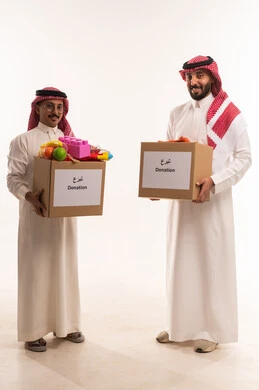 ألعاب أطفال للتبرع وادخال البهجة على قلب الصغار، حمل صندوق التبرعات للمشاركة في الثواب،  جمعيات اسلامية في السعودية، المساعدة على توفير الاحتياجات، بورتريه لرجلان خليجيان عربيان سعوديان يقومان بتجهيز صندوق التبرع، توزيع الحصص المجهزة، خلفية بيضاء