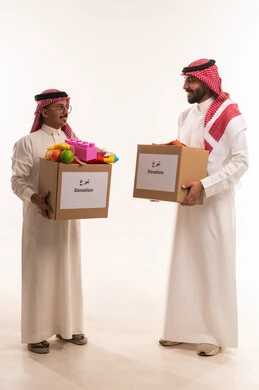 حمل صندوق التبرعات للمشاركة في الثواب، ألعاب أطفال للتبرع وادخال البهجة على قلةب الصغار، جمعيات اسلامية في السعودية، المساعدة على توفير الاحتياجات، بورتريه لرجلان خليجيان عربيان سعوديان يقومان بتجهيز صندوق التبرع، توزيع الحصص المجهزة، خلفية بيضاء