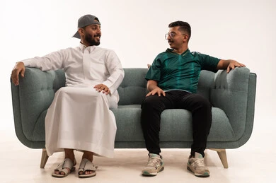 المناقشة والحوار حول المباريات، قضاء اوقات الفراغ الممتعة مع الاصدقاء، الحماس والتفاعل مع المنتخب، الشغف في متابعة فريق المنتخب الوطني، بورتريه لرجلين عربيين خليجيين سعوديين احدهما يرتدي الثوب التقليدي، شاب سعودي يرتدي قميص المنتخب السعوديي، خلفية بيضاء