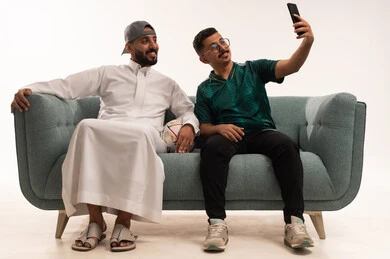 صور تذكارية خلال التشجيع، التفاعل بمشاهدة الفريق المفضل, ايماءات التحدي والانتصار، قضاء اوقات الفراغ الممتعة مع الاصدقاء، أنشطة رياضية ترفيهية،  بورتريه لرجلين عربيين خليجيين سعوديين احدهما يمسك بيده كرة، شاب سعودي يرتدي قميص المنتخب السعوديي، خلفية بيضاء