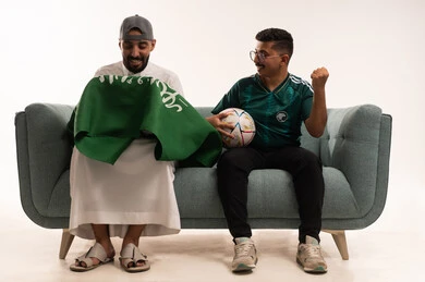 Contemplation of the green flag of the Kingdom, the passion for following the national team, recreational sports activities, a portrait of two Arab Gulf men from Saudi Arabia, one wearing traditional attire and holding the Kingdom's flag, a young Saudi man wearing the Saudi national team jersey and holding a ball, white background. Contemplation of the green flag of the Kingdom, the passion for following the national team, recreational sports activities, a portrait of two Arab Gulf men from Saudi Arabia, one wearing traditional attire and holding the Kingdom's flag, a young Saudi man wearing the Saudi national team jersey and holding a ball, white background.
