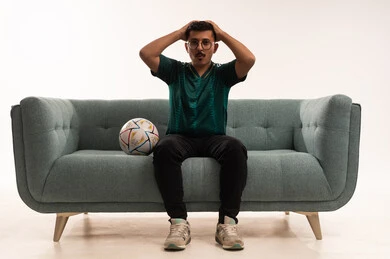 تعابير الحزن والخسارة وضع اليدين على الرأس، التفاعل بمشاهدة الفريق المفضل, ايماءات التحدي والانتصار، قضاء اوقات الفراغ الممتعة مع الاصدقاء، أنشطة رياضية ترفيهية،  بورتريه لشاب سعودي يرتدي قميص المنتخب السعوديي وبجانبه كرة، خلفية بيضاء