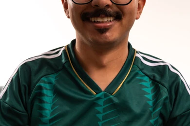 ابتسامة وتعابير سعادة وسرور، قضاء وقت ممتع بمشاهدة ومتابعة المباراة، التفاعل بمشاهدة الفريق المفضل, ايماءات التحدي والانتصار، الألعاب والمباريات الرياضية, أنشطة رياضية ترفيهية،  بورتريه مقرب لشاب سعودي يرتدي قميص المنتخب السعوديي ويضع نظارة طبية، خلفية بيضاء