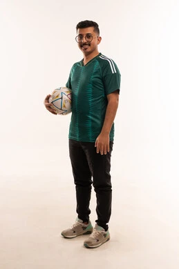 قضاء وقت ممتع بمشاهدة ومتابعة المباراة، ايماءات الفرح بالنجاح والفوز، الانجاز وتحقيق الاهداف، التفاعل بمشاهدة الفريق المفضل، الألعاب والمباريات الرياضية, أنشطة رياضية ترفيهية،  بورتريه لشاب سعودي يرتدي قميص المنتخب السعوديي و يحمل بيده كرة، خلفية بيضاء