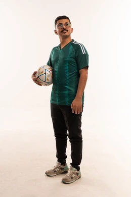 التأمل والخيال بفوز المنتخب المفضل، قضاء وقت ممتع بمشاهدة ومتابعة المباراة، الانجاز وتحقيق الاهداف، التفاعل بمشاهدة الفريق المفضل، الألعاب والمباريات الرياضية, أنشطة رياضية ترفيهية،  بورتريه لشاب سعودي يرتدي قميص المنتخب السعوديي و يحمل بيده كرة، خلفية بيضاء