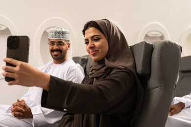 The concept of marriage and connection, an Arab Gulf Omani woman wearing a hijab and abaya sitting inside an airplane on a flight with her husband taking commemorative selfies using a mobile phone, spending friendly times between the couple, documenting happy moments, modern devices and technologies. The concept of marriage and connection, an Arab Gulf Omani woman wearing a hijab and abaya sitting inside an airplane on a flight with her husband taking commemorative selfies using a mobile phone, spending friendly times between the couple, documenting happy moments, modern devices and technologies.