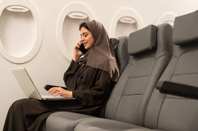 الرد على الاتصالات والمكالمات, استخدام جهاز تقني حديث ومتطور, التواصل مع العائلة والأصدقاء, إجراء مكالمة هاتفية عبر الجوال, امراة عربيه خليجيه عمانية ترتدي الحجاب و العباءة تجلس داخل الطائرة فى رحلة جويه تعمل على الحاسب المحمول, مفهوم السياحة و السفر الرد على الاتصالات والمكالمات, استخدام جهاز تقني حديث ومتطور, التواصل مع العائلة والأصدقاء, إجراء مكالمة هاتفية عبر الجوال, امراة عربيه خليجيه عمانية ترتدي الحجاب و العباءة تجلس داخل الطائرة فى رحلة جويه تعمل على الحاسب المحمول, مفهوم السياحة و السفر