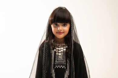 Saudi National Day, September 23, celebrating the founding of the first Saudi state on February 22, looking at the camera with gestures of pride in Saudi heritage, wearing the northern region costume, the day of our beginnings 1727 AD, close-up portrait of a smiling Saudi Arabian Gulf girl wearing a muhthal and a sheyla, white background