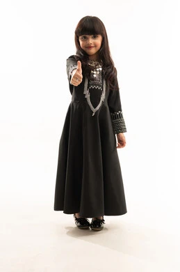 النظر إلى الكاميرا ورفع إصبع الإبهام للأعلى بإيماءات الإعجاب، ارتداء زي المنطقة الشمالية, يوم بدينا 1727م, ذكرى تأسيس الدولة السعودية الأولى في 22 فبراير, بورتريه لفتاة عربية خليجية سعودية مبتسمة ترتدي المحوثل الأسود, الجسم بالطول الكامل, خلفية بيضاء