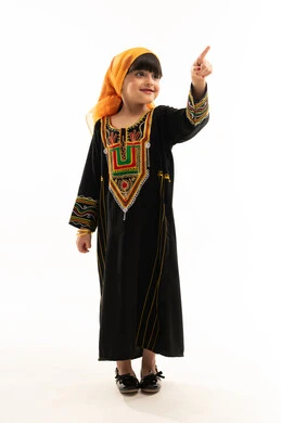 الإشارة بإصبع السبابة إلى الأعلى، الفخر بالتراث السعودي، ارتداء أزياء المنطقة الجنوبية في المناسبات الوطنية, يوم بدينا 1727م, ذكرى تأسيس الدولة السعودية الأولى في 22 فبراير, بورتريه لفتاة عربية خليجية سعودية ترتدي الشيلة والسدرة, الجسم بالطول الكامل, خلفية بيضاء