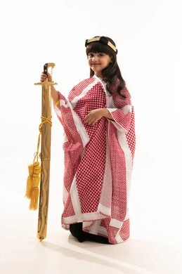 الأزياء الشعبية في اليوم الوطني السعودي 23سبتمبر, الفخر بالتراث السعودي، يوم بدينا 1727م, بورتريه لفتاة عربية خليجية سعودية مبتسمة تمسك بيدها السيف وترتدي البشت وعقال يوم تأسيس الدولة السعودية الأولى في 22 فبراير, الجسم بالطول الكامل, خلفية بيضاء