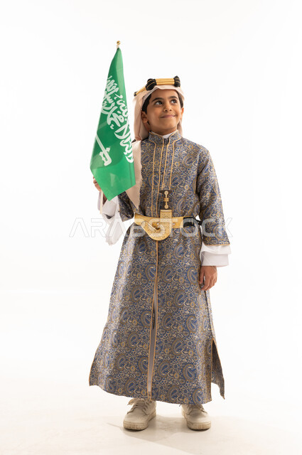 اليوم الوطني السعودي 23سبتمبر، يوم العلم 11مارس، تأسيس الدولة السعودية 22 فبراير، ارتداء أزياء المنطقة الوسطى في المناسبات الوطنية، يوم بدينا 1727 م، بورتريه لولد عربي خليجي سعودي يرتدي الدقلة والخنجر وعقال التأسيس يحمل العلم، صورة لكامل الجسم، خلفية بيضاء
