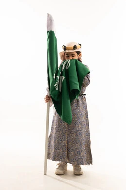 إحياء التراث السعودي، ارتداء أزياء المنطقة الوسطى في المناسبات الوطنية، يوم بدينا 1727 م، بورتريه لولد عربي خليجي سعودي مبتسم يرتدي الدقلة والخنجر والعقال التقليدي يقوم بتقبيل علم تأسيس الدولة السعودية 22 فبراير، صورة لكامل الجسم، خلفية بيضاء