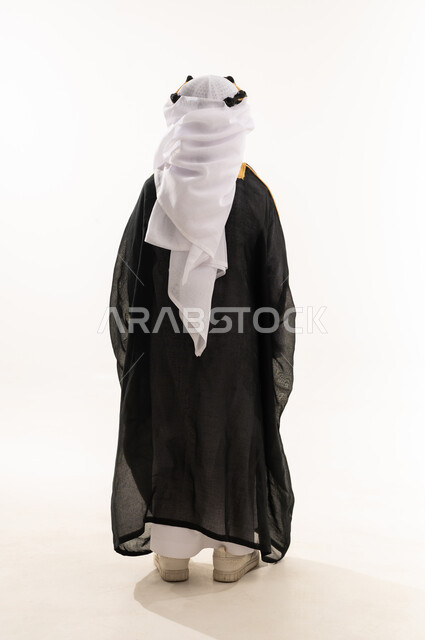 Saudi National Day, September 23, the day we began in 1727 AD, the celebration of the founding of the Saudi state, February 22, wearing the costumes of the Eastern Province on national occasions, a portrait from the back of a Saudi Arabian Gulf boy wearing a bisht, ghutra, and founding agal, a full body photo, white background