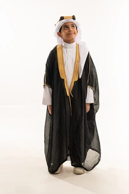 ذكرى تأسيس الدولة السعودية 22 فبراير، الوقوف باستقامة والنظر إلى الاعلى بفخر، ارتداء أزياء المنطقة الشرقية في المناسبات الوطنية، يوم بدينا 1727 م، بورتريه لولد عربي خليجي سعودي مبتسم يرتدي البشت والغترة وعقال التأسيس، صورة لكامل الجسم، خلفية بيضاء