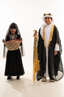 Popular handicrafts, looking at the camera with proud gestures, Saudi traditional costume for national occasions, founding of the first Saudi state, February 22, the day we began, 1727 AD, portrait of a smiling Saudi Arabian Gulf boy and girl holding a golden sword and a straw basket, full body, white background Popular handicrafts, looking at the camera with proud gestures, Saudi traditional costume for national occasions, founding of the first Saudi state, February 22, the day we began, 1727 AD, portrait of a smiling Saudi Arabian Gulf boy and girl holding a golden sword and a straw basket, full body, white background