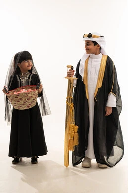 مهن وحرف يدوية شعبية، النظر إلى الاعلى بايماءات السعادة، زي تراثي سعودي للمناسبات الوطنية، تأسيس الدولة السعودية الأولى 22 فبراير، يوم بدينا 1727 م، بورتريه لولد وبنت عربيين خليجيين سعوديين مبتسمين يحملان سيف ذهبي وسلة قش، الجسم بالطول الكامل، خلفية بيضاء