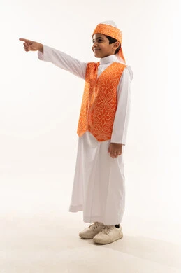 Pointing with index finger, wearing western region costumes on national occasions, pride in Saudi heritage, the day of our beginnings 1727 AD, side portrait of a smiling Saudi Arabian Gulf boy wearing the traditional Sudairi, anniversary of the founding of the Saudi state February 22, full body photo, white background