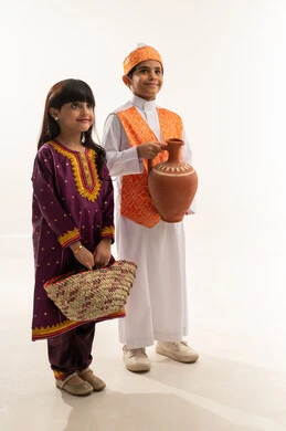 مشغولات يدوية شعبية، النظر إلى الكاميرا بايماءات السعادة، زي تراثي سعودي في اليوم الوطني 23سبتمبر، تأسيس الدولة السعودية الأولى 22 فبراير، يوم بدينا 1727 م، بورتريه لولد وبنت عربيين خليجيين سعوديين مبتسمين يحملان إناء من الفخار وسلة قش، الجسم بالطول الكامل، خلفية بيضاء