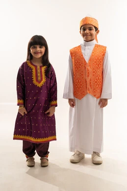 النظر إلى الكاميرا بايماءات السعادة، الفخر بالهوية السعودية، زي تراثي سعودي لللمناسبات الوطنية، ذكرى تأسيس الدولة السعودية الأولى 22 فبراير، يوم بدينا 1727 م، بورتريه لولد وبنت عربيين خليجيين سعوديين مبتسمين، الجسم بالطول الكامل، خلفية بيضاء