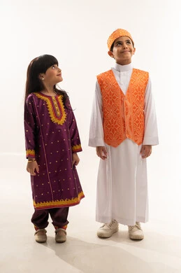 إظهار الحب والولاء للوطن، زي تراثي في العيد الوطني السعودي 23سبتمبر، ذكرى تأسيس الدولة السعودية الأولى 22 فبراير، يوم بدينا 1727 م، بورتريه لولد وبنت عربيين خليجيين سعوديين مبتسمين ينظران إلى شيء ما، الجسم بالطول الكامل، خلفية بيضاء